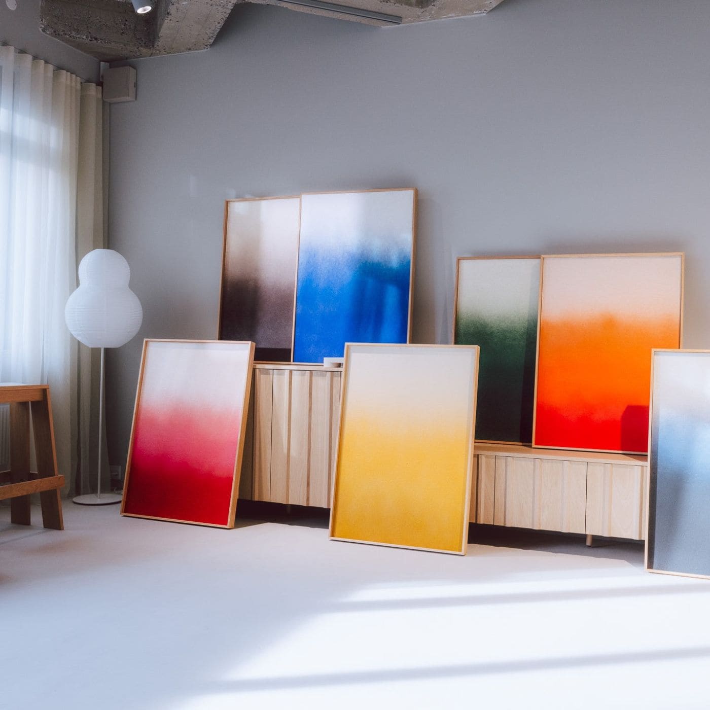 Farverige værker fra Anne Nowaks kollektion udstillet i moderne interiør, inspireret af blød og stemningsfuld graffiti kunst.